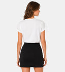 Vue arrière du t-shirt blanc ANI ARPÉ en coton avec manches à revers porté avec une jupe noire